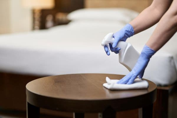 hands wiping a table with a cloth